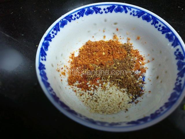 现在再说说油辣子怎么做，先把辣椒粉、花椒粉、芝麻、少许盐放入碗中。
