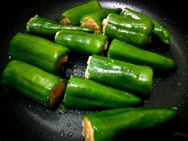 热锅放油、青椒竖起来煎一下（以防掉馅、煎一下能收口）、青椒再平放微微煎一下（可按个人喜欢、把青椒煎至虎皮状）