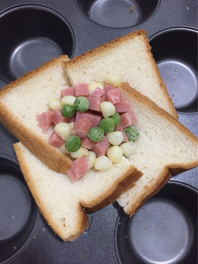 火腿切丁后和玉米粒青豆一同放入吐司中