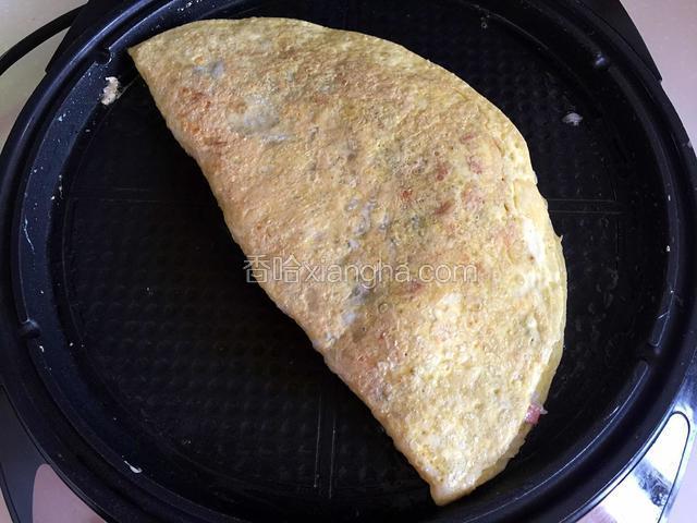 另一半蛋饼盖在炒饭上，蛋饼煎至金黄盛出。
