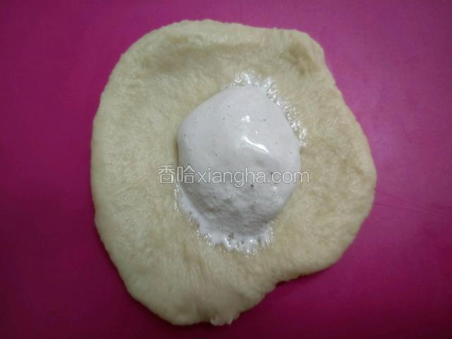 取一份面团擀开擀薄，中间放入fluff棉花糖，像包包子一样包起来，收口捏紧朝下。