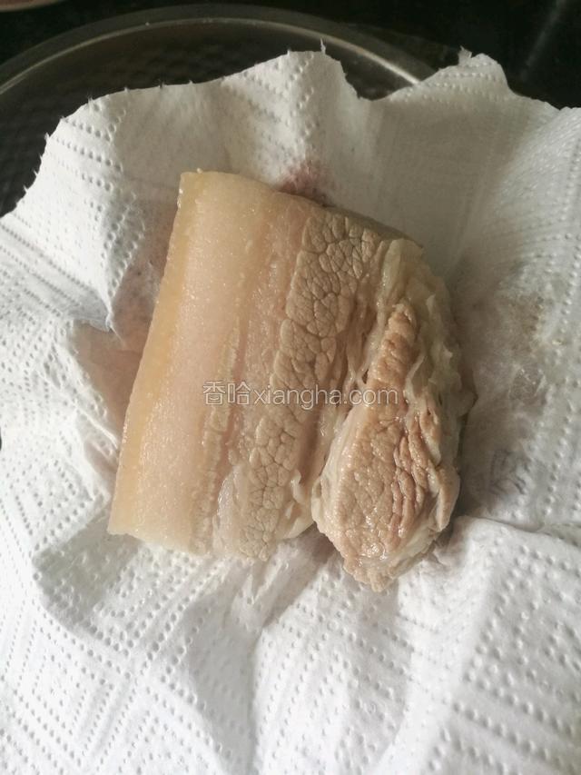 用厨房纸吸干肉块的水份，防止炸肉时外溅