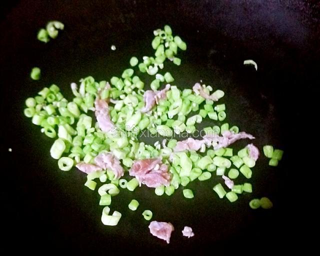 炒两三分钟后，倒入瘦肉翻炒五分钟左右
