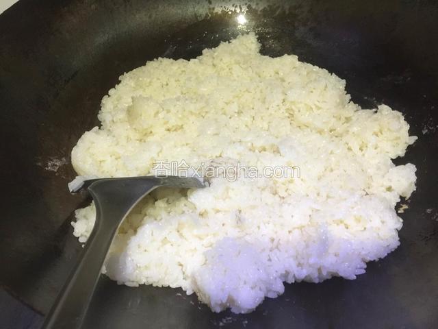 热锅里放入适量食用油，倒入熟糯米饭翻炒几下；