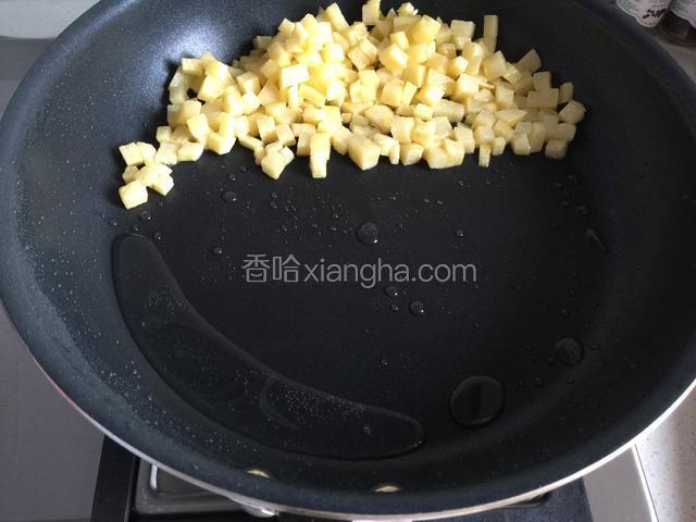 转中火将土豆丁推至一边，将锅倾斜让油滑落到底部。