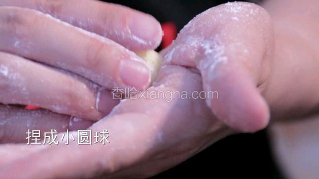在手上搓一层面粉，取适量的土豆泥揉捏成小圆球。