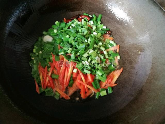 热锅凉油，待油温五六成热时放入干辣椒，蒜片爆香之后依次放入韭菜，红萝卜丝，红辣椒丝