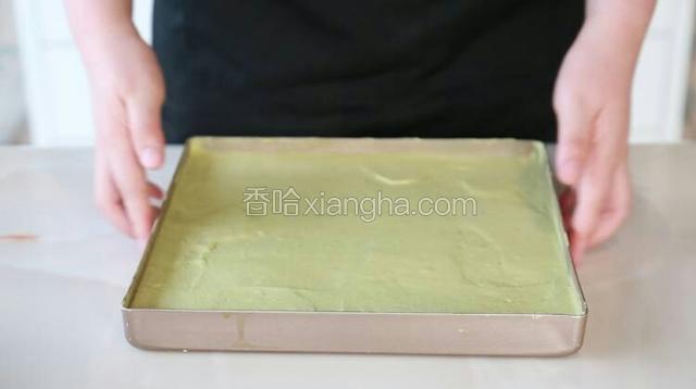 将混合好的蛋糕糊倒入烤盘、抹平，用手端住烤盘在桌上用力震两下，把内部的大气泡震出来。