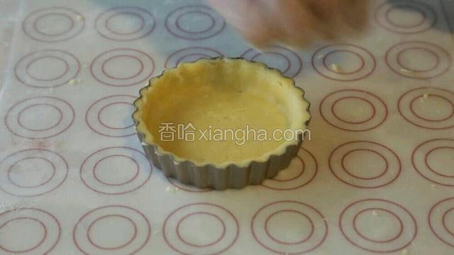 将静置好的面团擀薄，然后铺在模具上，再将面团按压成型