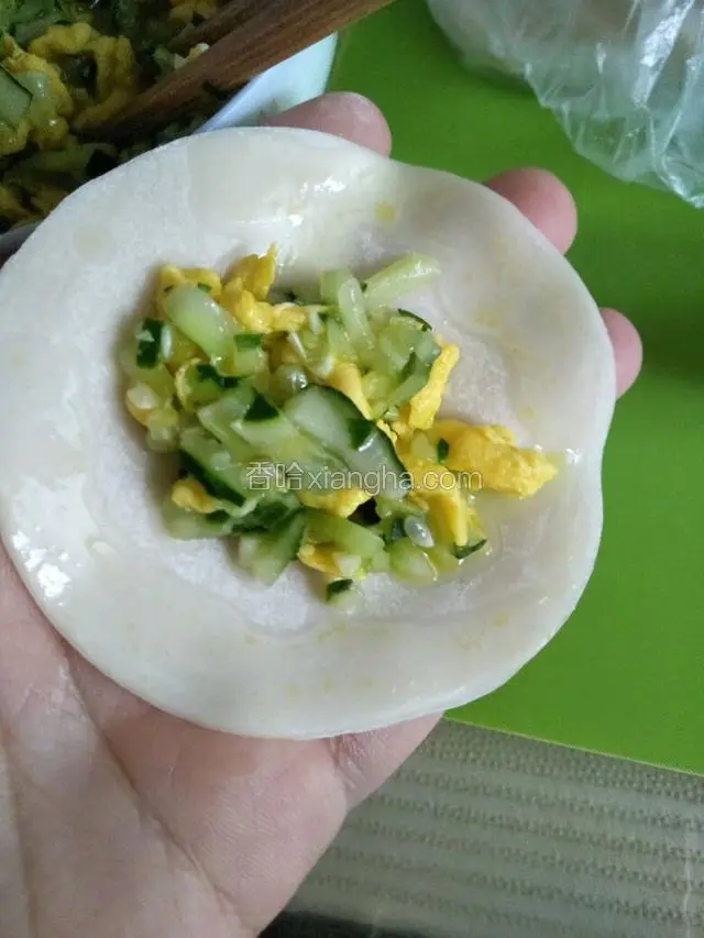 取一块饺子皮放入馅，饺子皮一圈蘸点水（这样包的紧煮的时候不容易破皮）