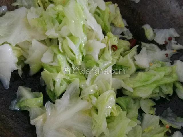 将热油浇在卷心菜上，加盐，搅拌