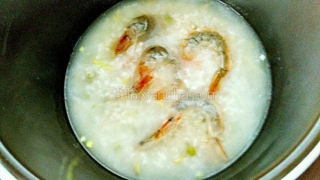 虾清洗干净备用，提前用料酒和盐腌十分钟，把大虾放入粥里煮