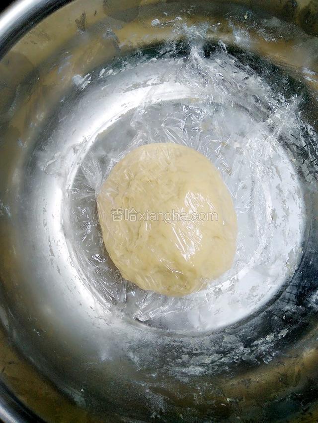 将面团再次揉搓一会，让面团排出内部的气泡，然后搓圆放盆子里用薄膜盖着松驰15分钟