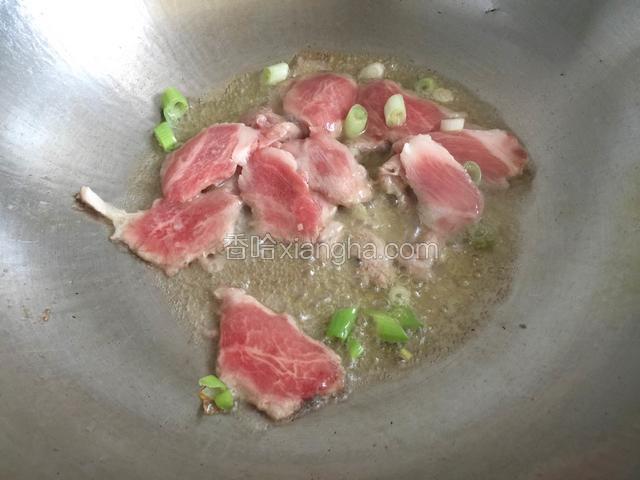 锅内放油烧至五成热，放入肉片和葱翻炒至肉片变色。