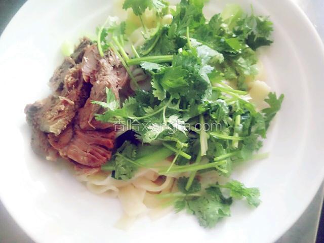 捞出面条，放入切好的牛肉片和香菜段