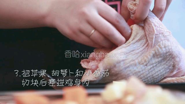 把苹果、胡萝卜和小番茄切块后塞进鸡身内。多余的苹果块等可以铺在装鸡的盘子上。