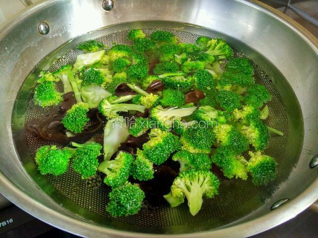 烧一锅开水，水中加一勺盐和几滴香油，放入木耳和西兰花焯三分钟，西兰花变成翠绿色即可捞出来。