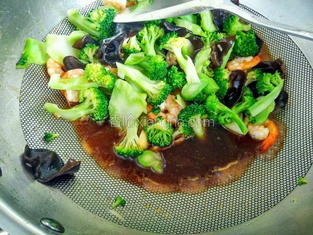 倒入虾球，西兰花和木耳，翻炒均匀。