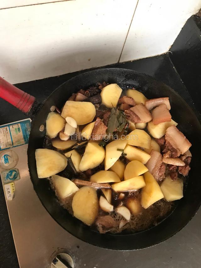大火煮至20分钟后加土豆放入蒜瓣继续加盖煮