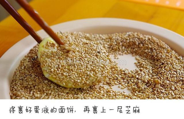 将裹好蛋液的面饼，再裹上一层芝麻，如果喜欢吃芝麻可以多裹一点~~