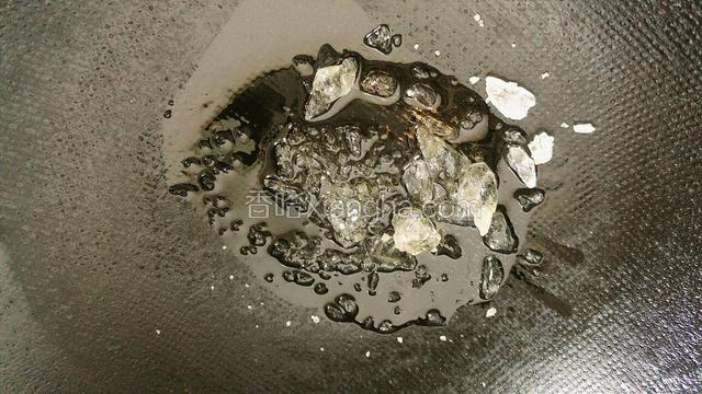 锅里放入老冰糖加花生油，小火熬制