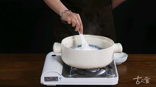 牛奶隔水加热，加入白糖搅拌至融化。