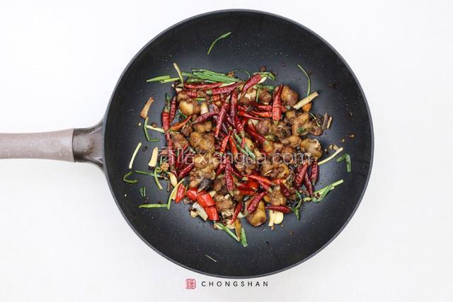 爆炒3分钟后，将干辣椒和花椒粒下锅，2分钟后转中火不断翻炒，待锅中的油汁被吸收，干辣椒和花椒焦香时即可出锅。