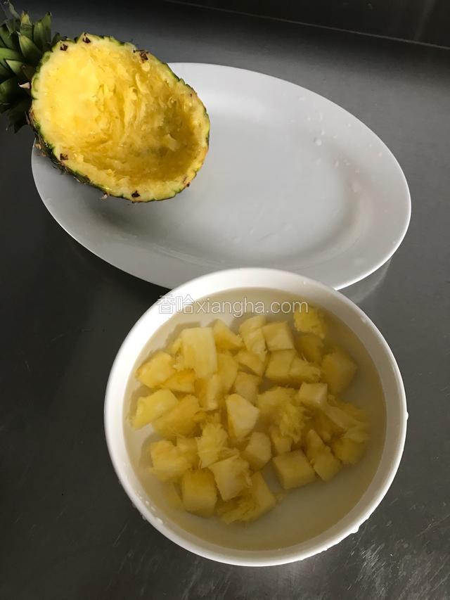 用勺子挖出菠萝，挖出的菠萝丁大多是长方形，用刀切成正方形，将菠萝加一勺盐泡水10分钟，菠萝壳冲洗干净，做点缀用