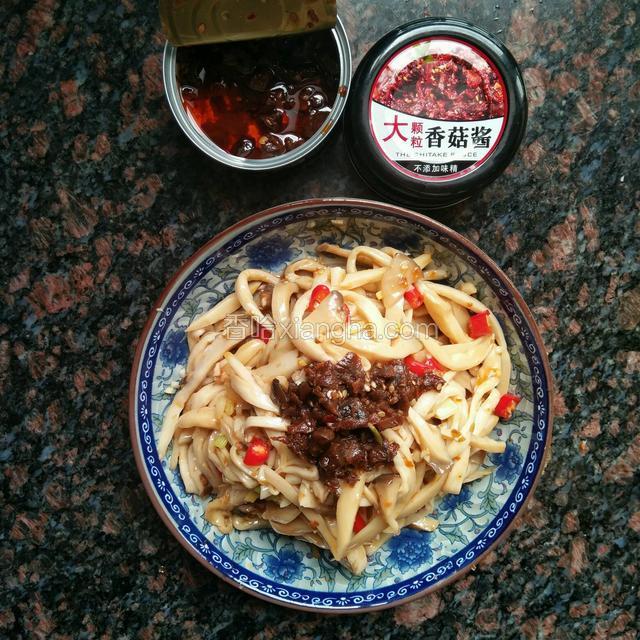 然后把最重要的香哈大颗粒香菇酱舀一勺浇在上面，再倒点香菇酱里面的油再次拌匀即可