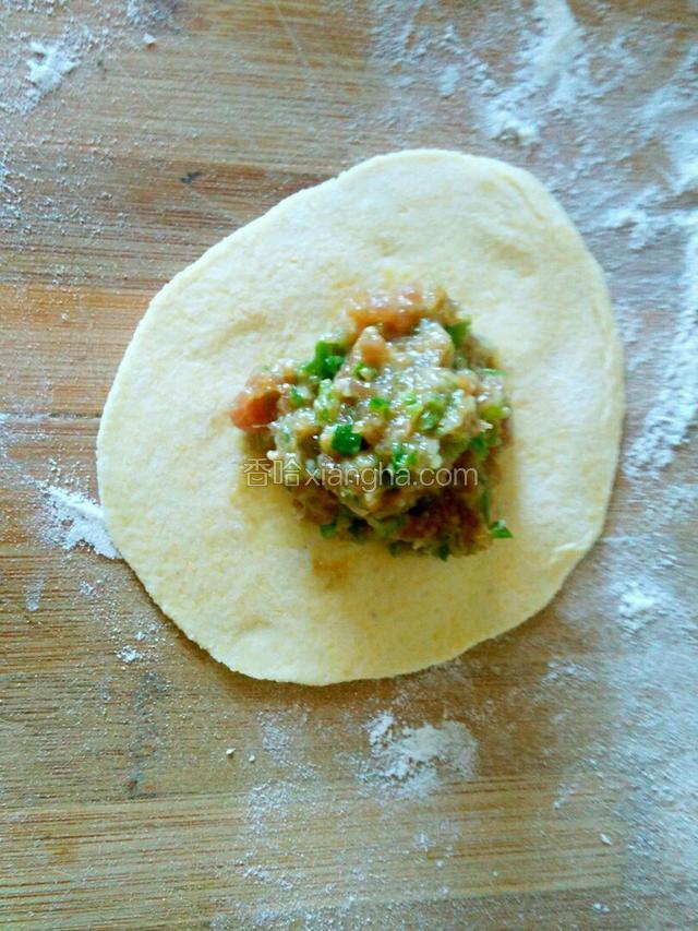 在饺子皮上放入肉馅