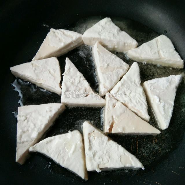 锅里热油，油热下入豆腐两面煎黄