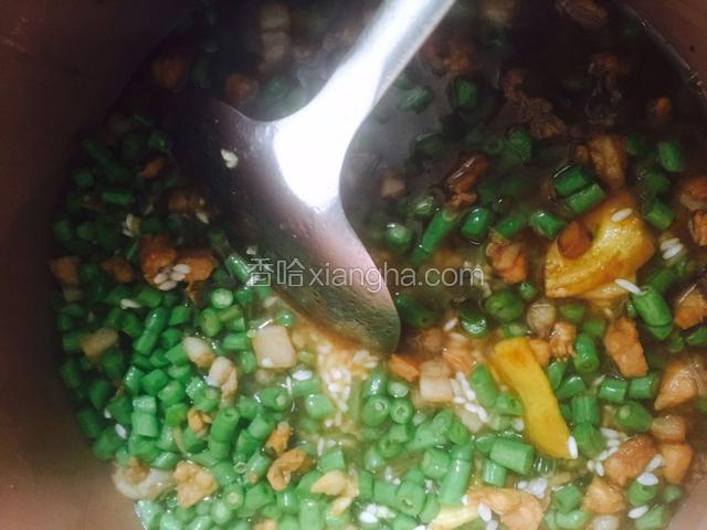把炒好的材料放进电饭煲里拌匀。