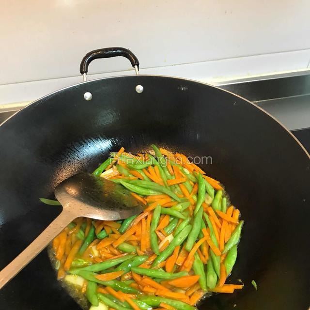 加一小碗水焖炒，至豆角变软，水熬下去差不多就熟了