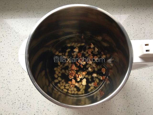 将泡好的黑米，黑豆，黄豆，核桃放入豆浆机的杯体中，加入适量清水。