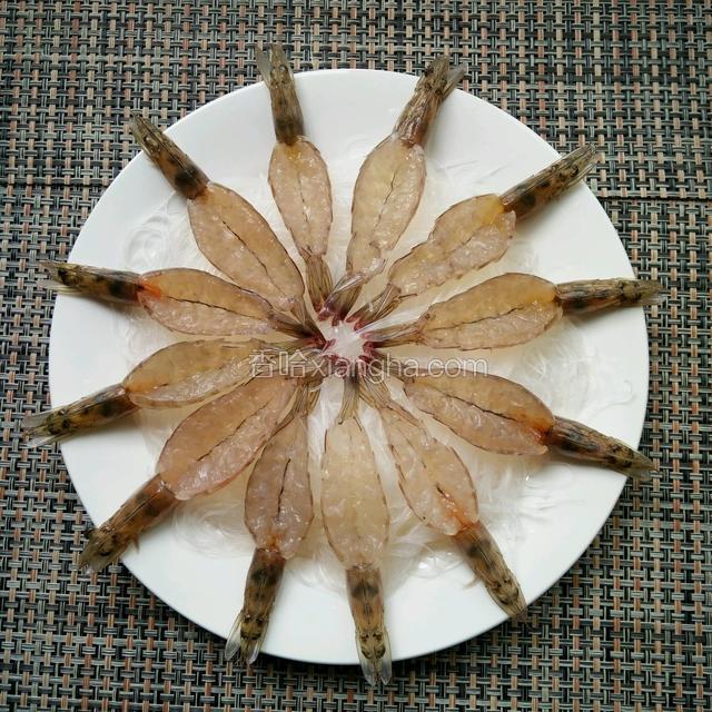全部处理完之后先把泡好的粉丝铺在盘底，在把虾均匀摆在粉丝上面