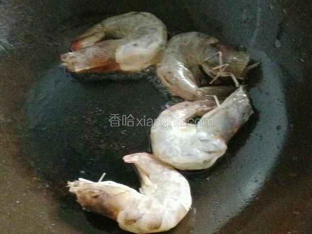 热油下锅，放入大虾煸炒