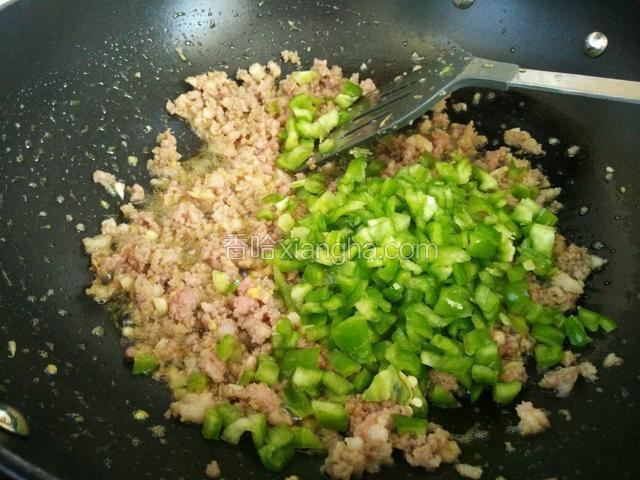 炒至猪肉泥断生或即将要断生的样子，加入青椒丁翻炒。
