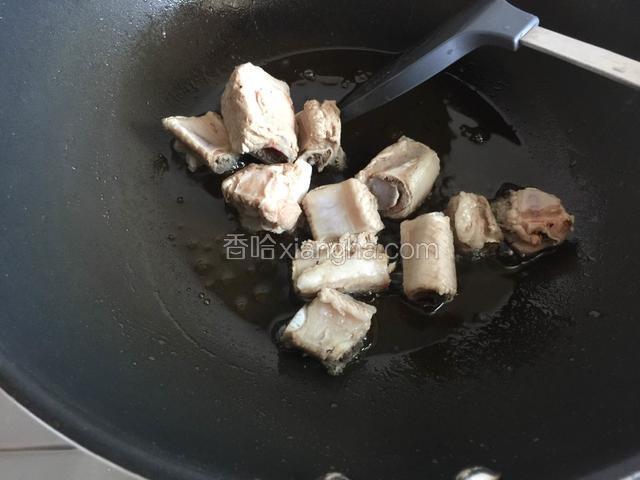 待冰糖融化呈微黄色，放入排骨翻炒均匀。