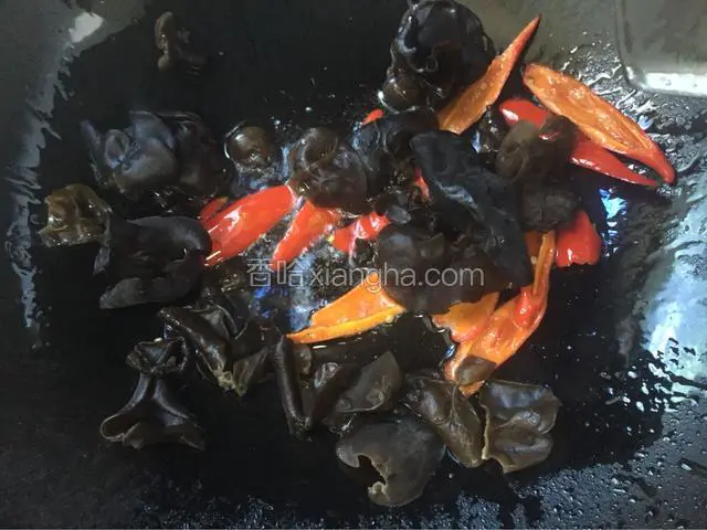 将黑木耳倒入锅中爆炒，至炒断生