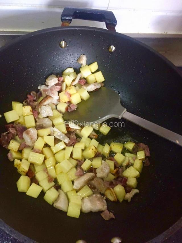 加入同样大小的五花肉块和广东正宗煌上煌腊肠丁持续翻炒