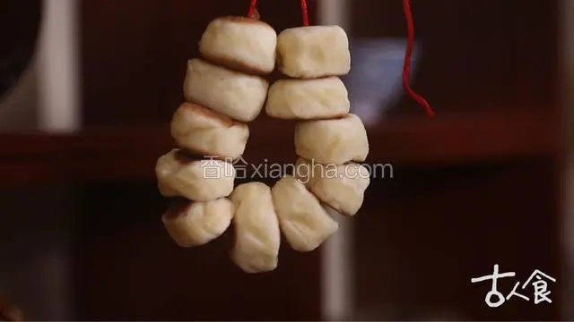 待面胚烙至两面金黄，笑靥儿即成，用红绳串起，便可欢欢喜喜的过七夕啦~