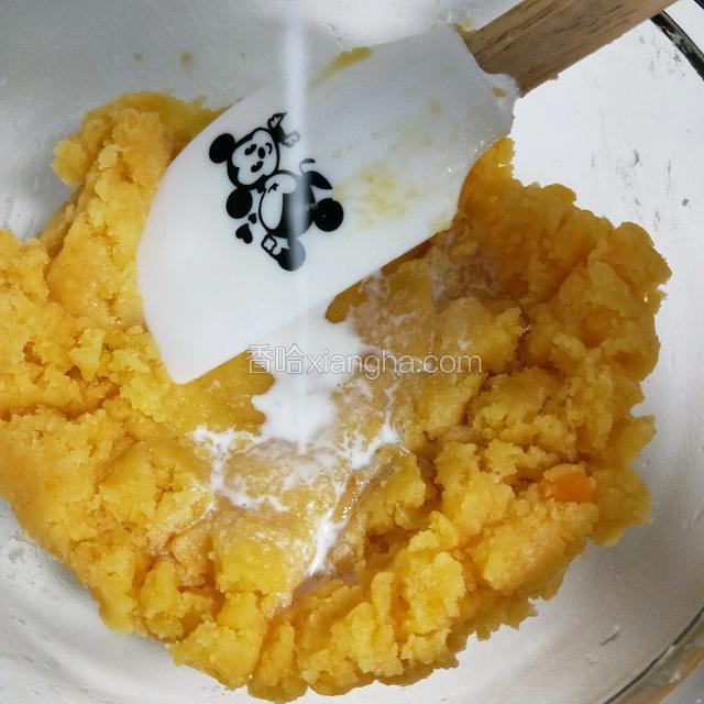 趁热倒入以上剩下的10克牛奶，翻拌均匀增加湿度。（这样做在高温烘烤的过程中，金沙奶黄就不会很干哦。）