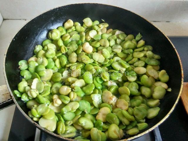 将酸菜下入锅中煸炒出香味，倒入蚕豆煸炒。注意轻轻翻动，因为蚕豆比较嫩。