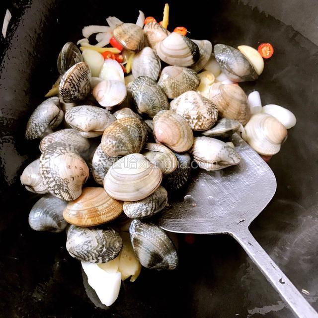 炒出香味放入花蛤，用铲子翻炒片刻