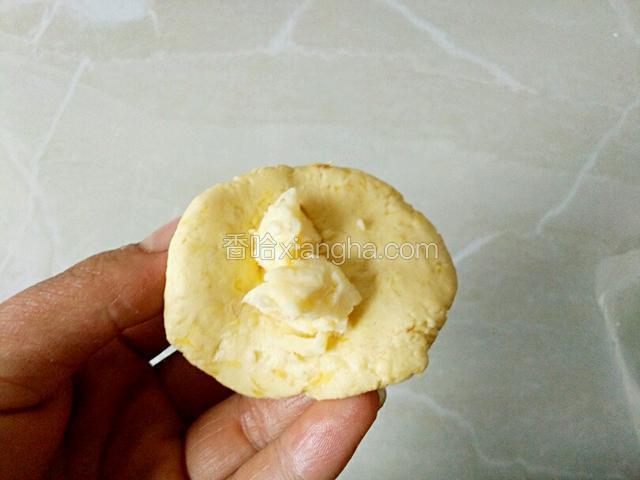 取适量面团按成饼状包入适量奶酪包好搓圆