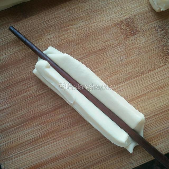 用筷子从中间按压出一条线，然后再可以扯长一些