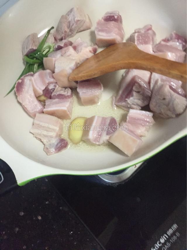 把切好洗干净控水的五花肉块投进锅中煸炒，