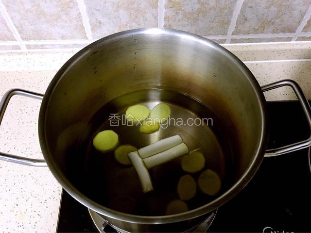 另起锅，水一次加够没过排骨，放入料酒葱段姜片，大火烧开