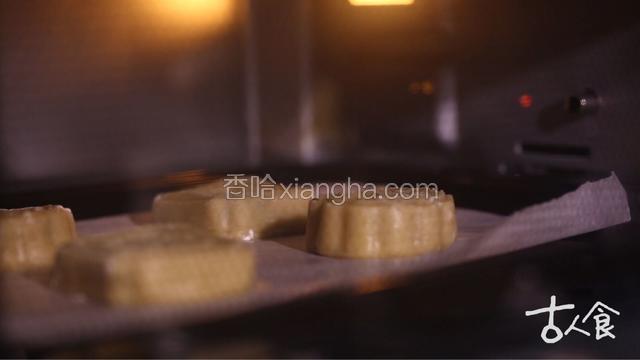 所有月饼胚都压好后，表面喷水，放入预热好的烤箱内，中层、上下火、二百度，烘烤五分钟左右取出