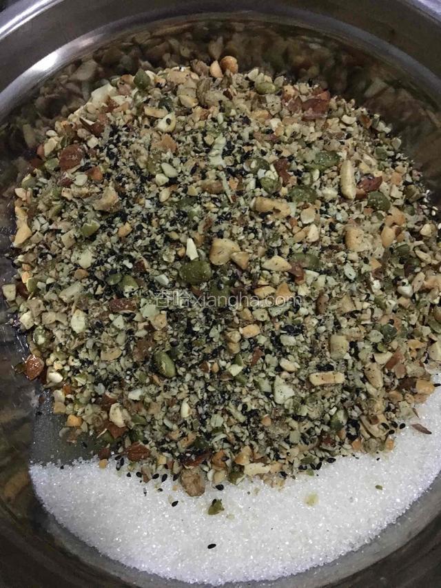 把熟的全部用袋子装起，用擀面杖擀碎后倒入盆里，把糖和玉米油放入果仁盆里。